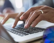 Man skriver på en bærbar